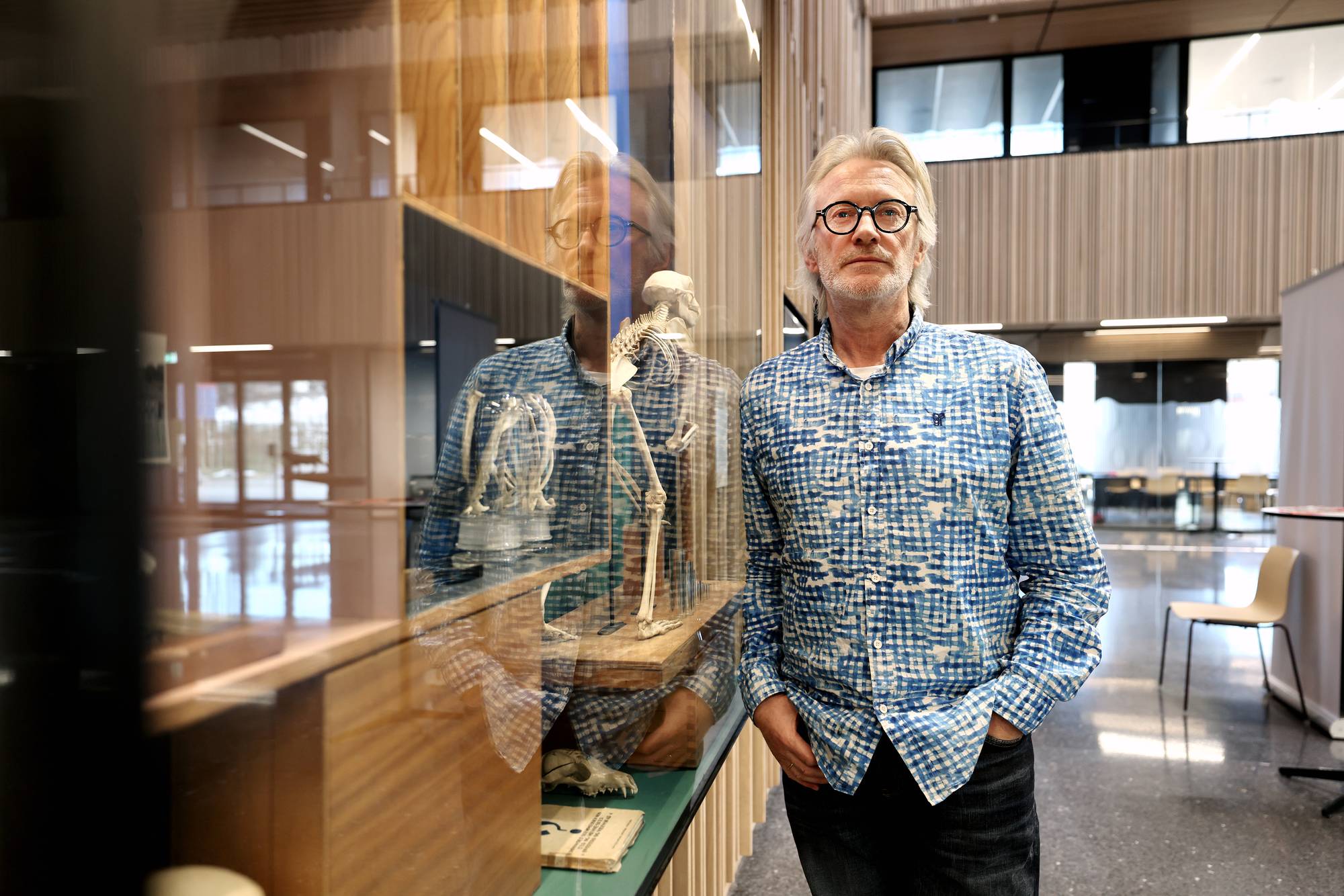 en mann som står foran en glassmonter