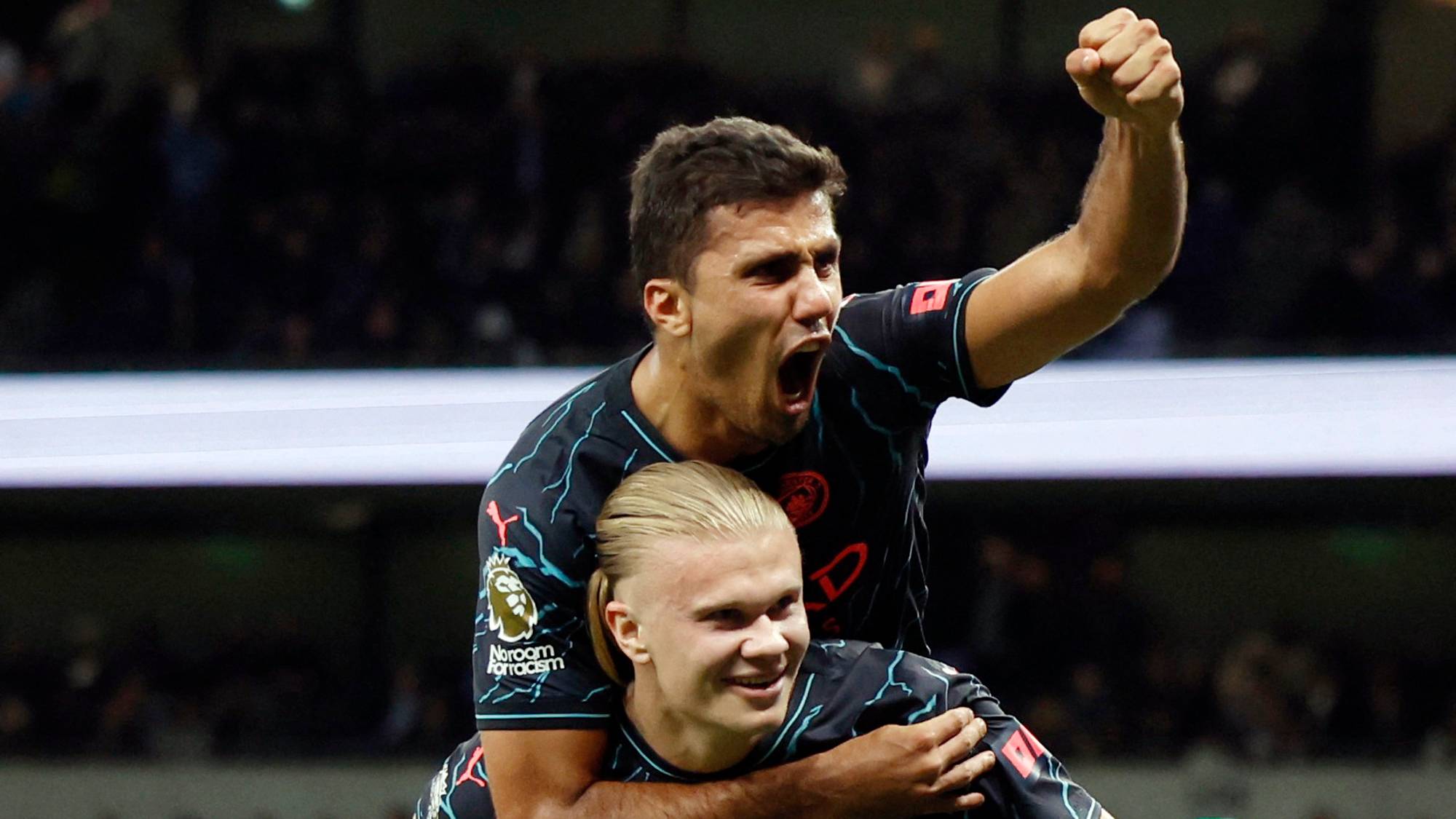 Rodri feirer mål med Erling Braut Haaland på ryggen under en fotballkamp for Manchester City. (Bildebeskrivelsen er laget av en KI-tjeneste)
