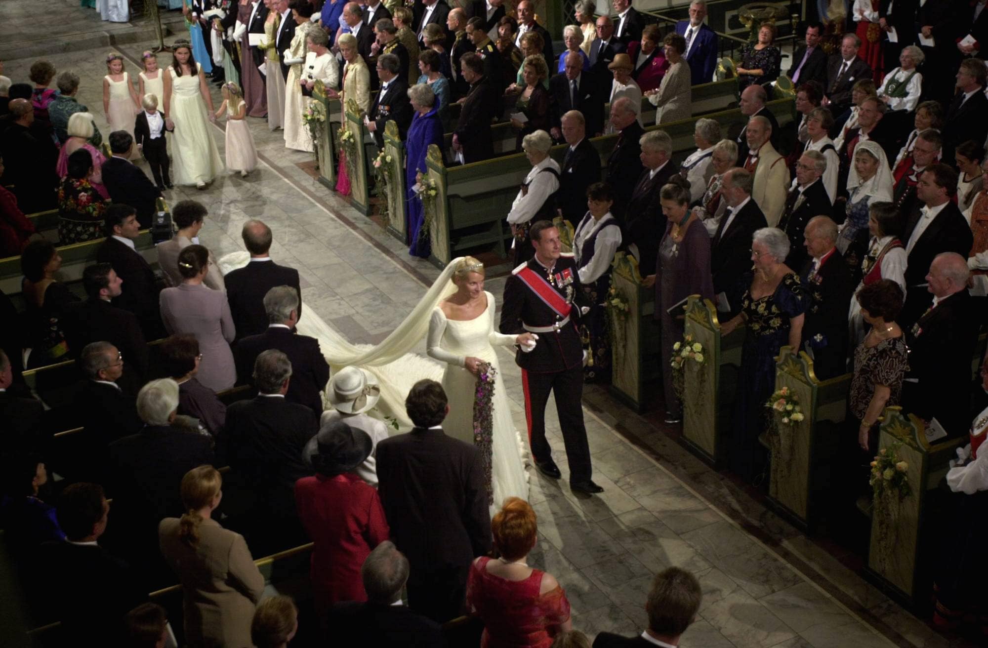Kronprins Haakon og kronprinsesse Mette-Marit går arm i arm i Oslo domkirke etter å ha blitt viet 25. august 2001