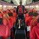 Photo: Oddgeir Øystese/NRK Bryan players sit in red airplane seats on a plane to Kazakhstan.