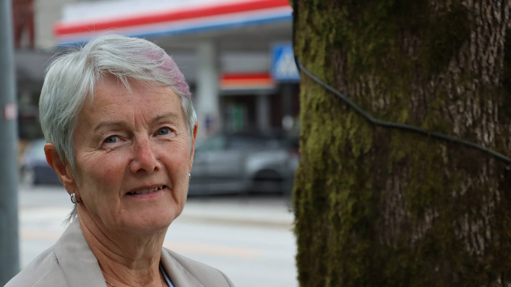 Dame som står ved eit tre