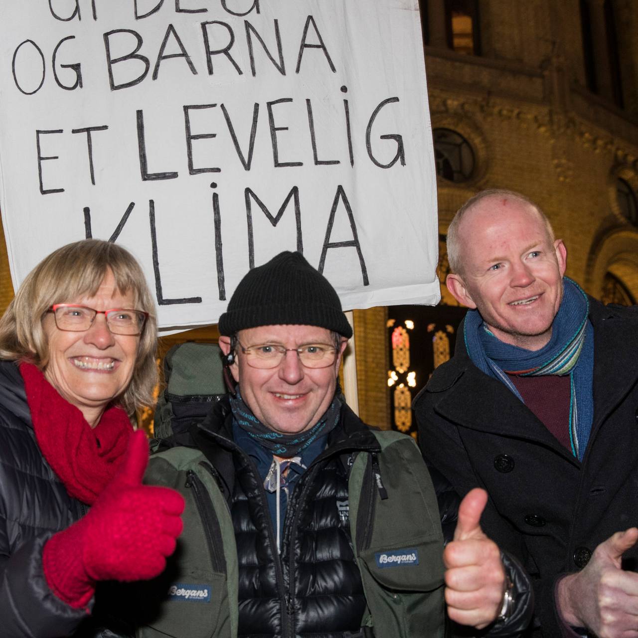 Karin Andersen, Thomas Cottis og Lars Haltbrekken utenfor Stortinget med plakat med budskap om å redde klima.