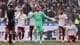 Andrew Couldridge / REUTERS,NTB En fotballkeeper i grønn drakt gestikulerer mot dommeren. Flere spillere i hvite drakter står rundt på gressbanen. Publikum ser på fra tribunen bak et målnett. (Bildebeskrivelsen er laget av en KI-tjeneste)