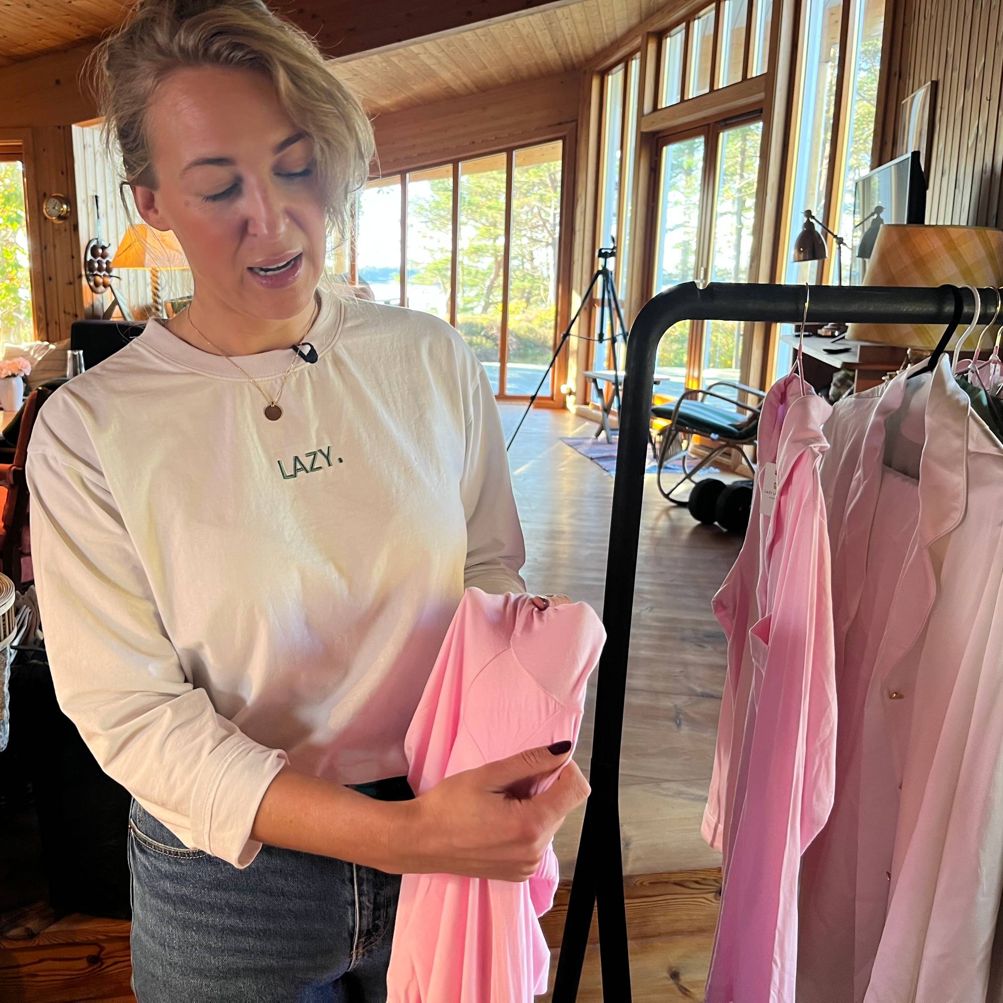 En kvinne viser frem et rosa klesplagg
