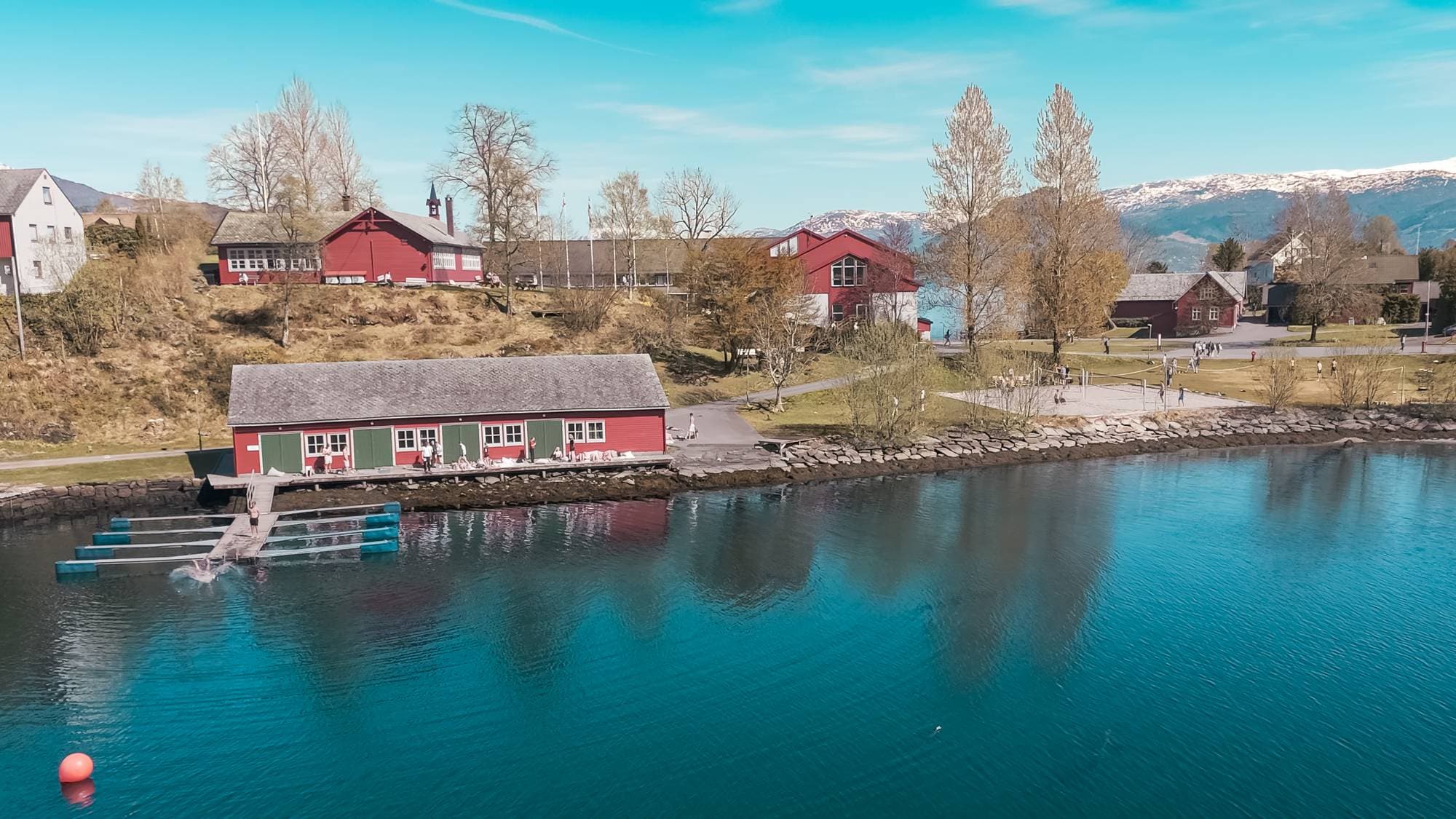 et vannområde med bygninger og trær rundt seg (Bildebeskrivelsen er laget av en KI-tjeneste)