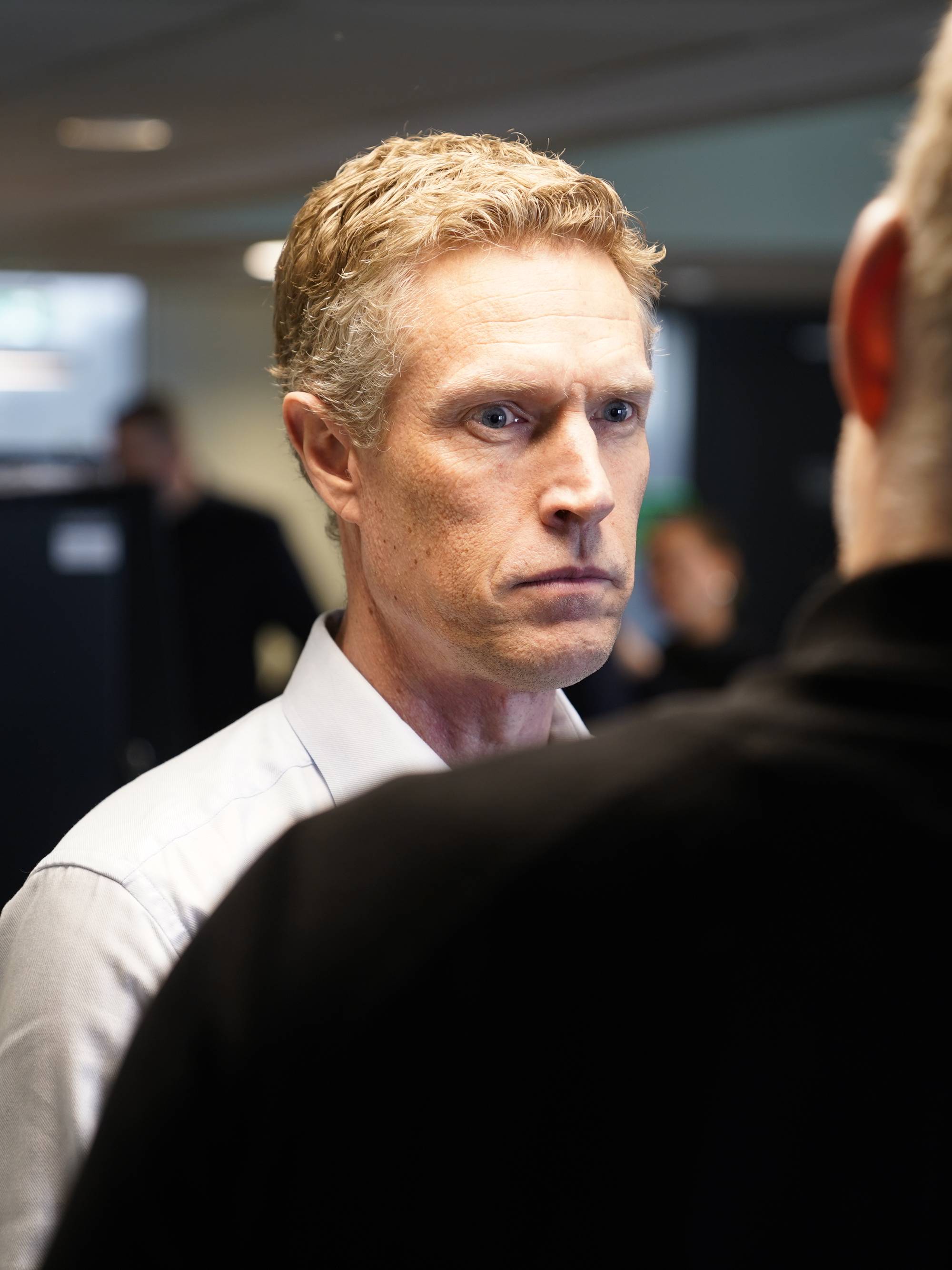 Mann i hvit skjorte ser streng ut