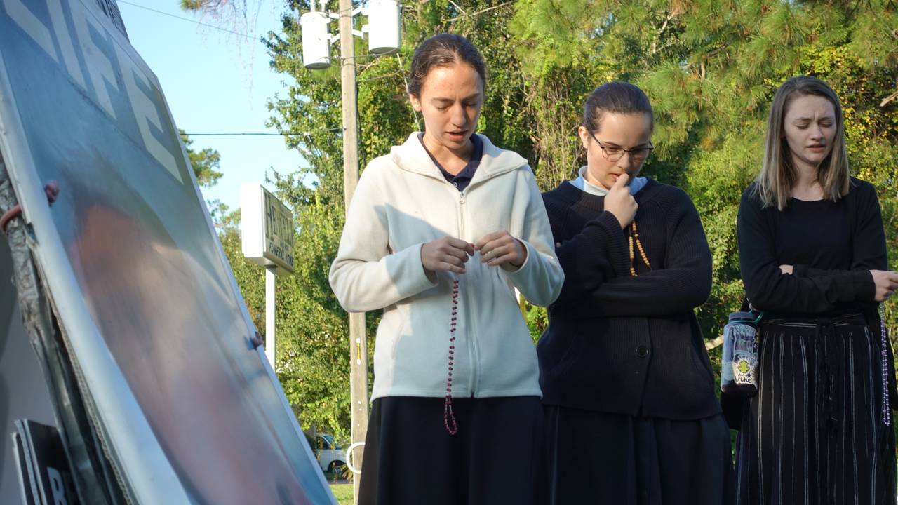 BER FOR FORBUD: Nancy McAndrew (22) (t.v), Hayden (18) og Lexi (18) samles til bønn foran abortklinikken. De går alle på katolsk skole i Florida.