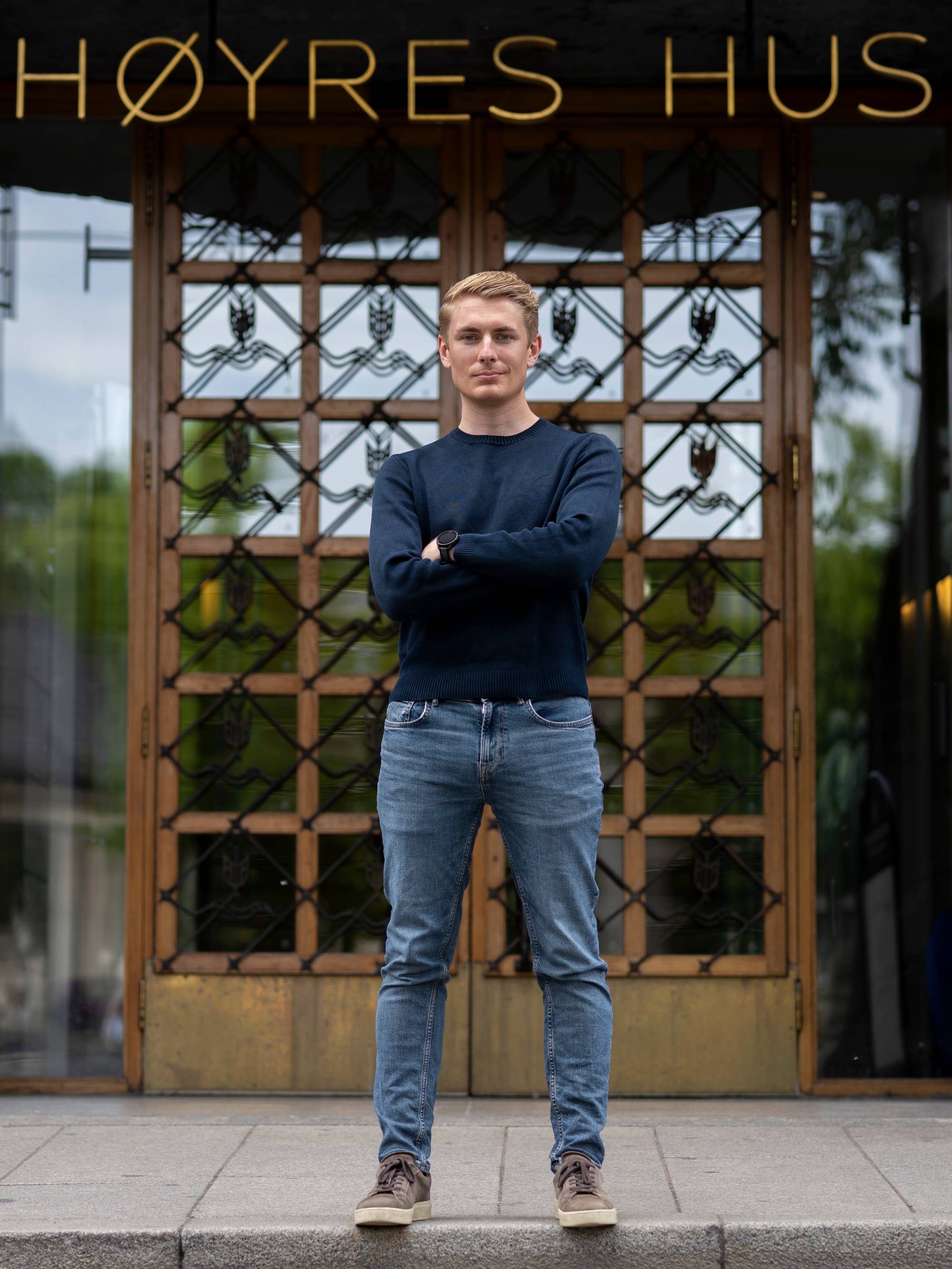 Mann står foran inngangen til Høyres Hus i Oslo. (Bildebeskrivelsen er laget av en KI-tjeneste)