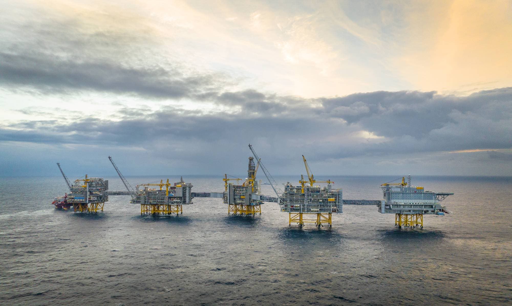 Plattformene på Johan Sverdrup-feltet som står i havet under dramatisk skydannelse.