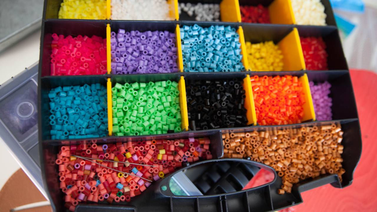 Verktøykasse full av perler i forskjellige farger
