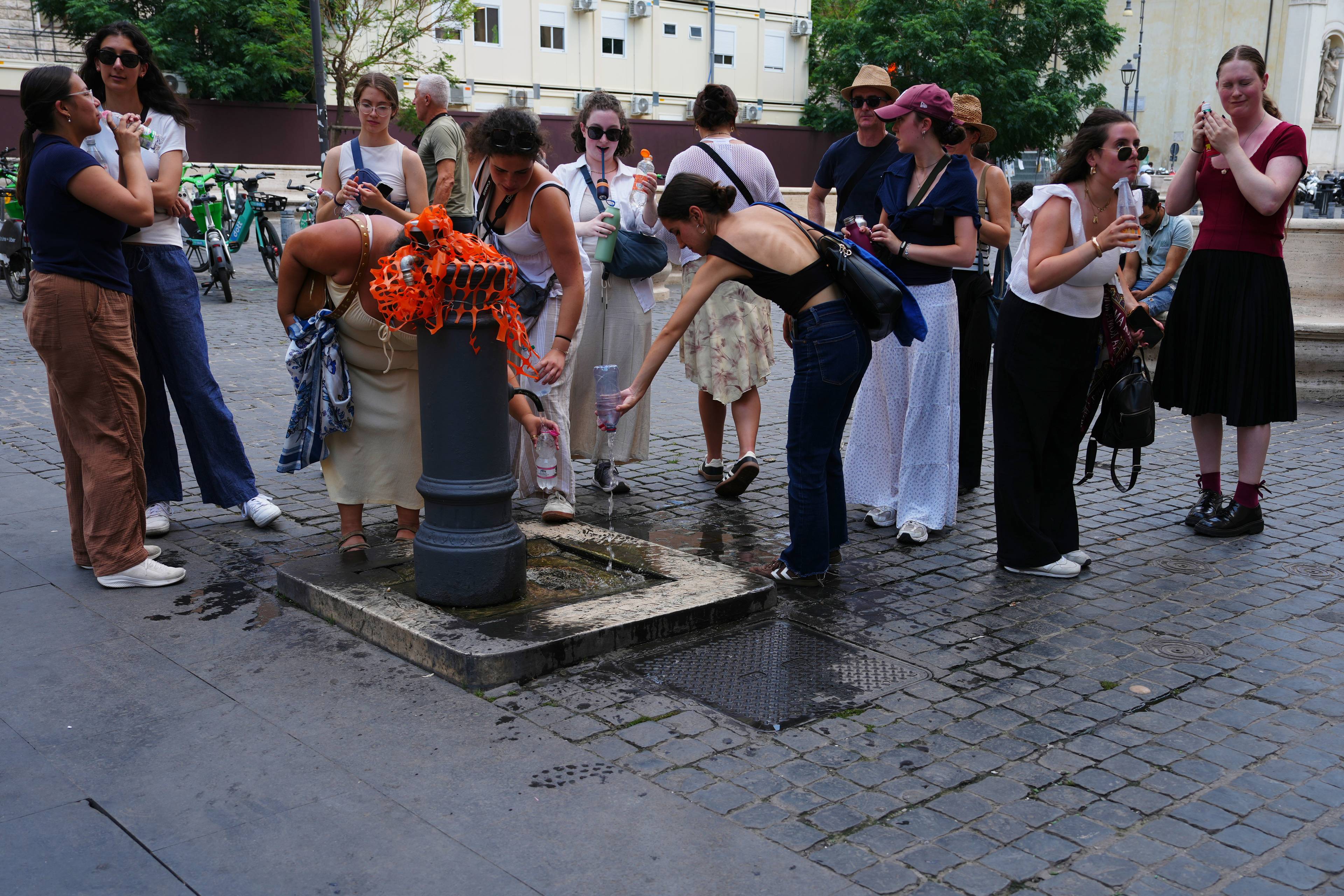 Folk ved en drikkefontene i Roma.
