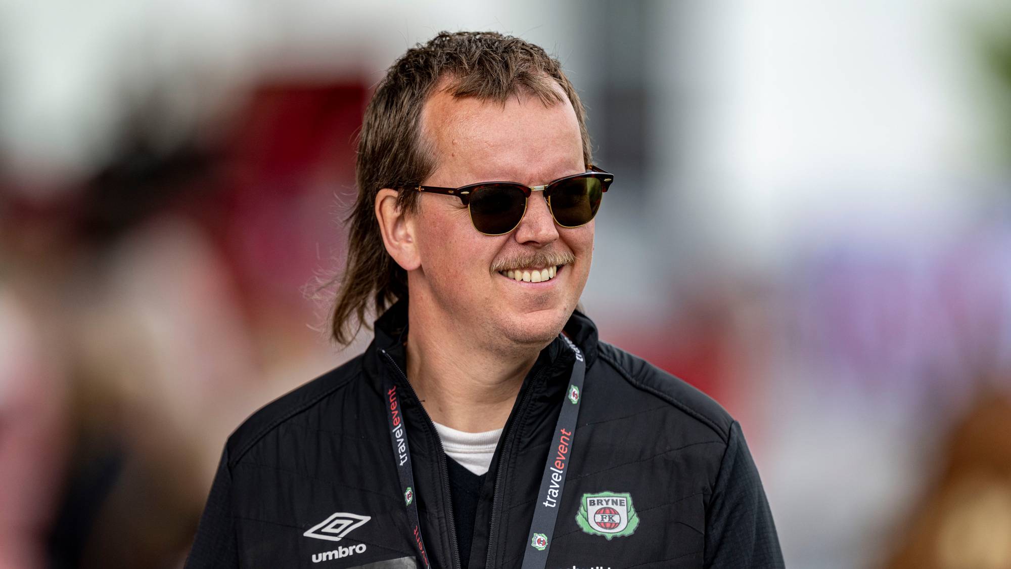 Portrett av mann med solbriller i Bryne FK-jakke. (Bildebeskrivelsen er laget av en KI-tjeneste)