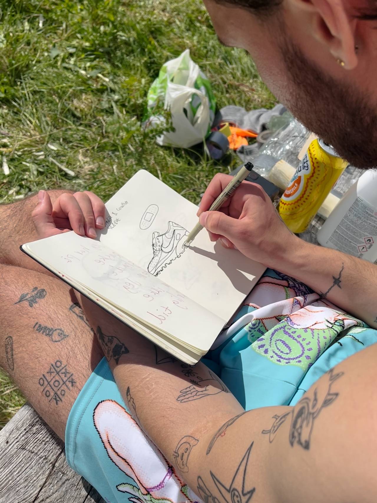 Robin Pereira tegner tatoveringer i boka si.