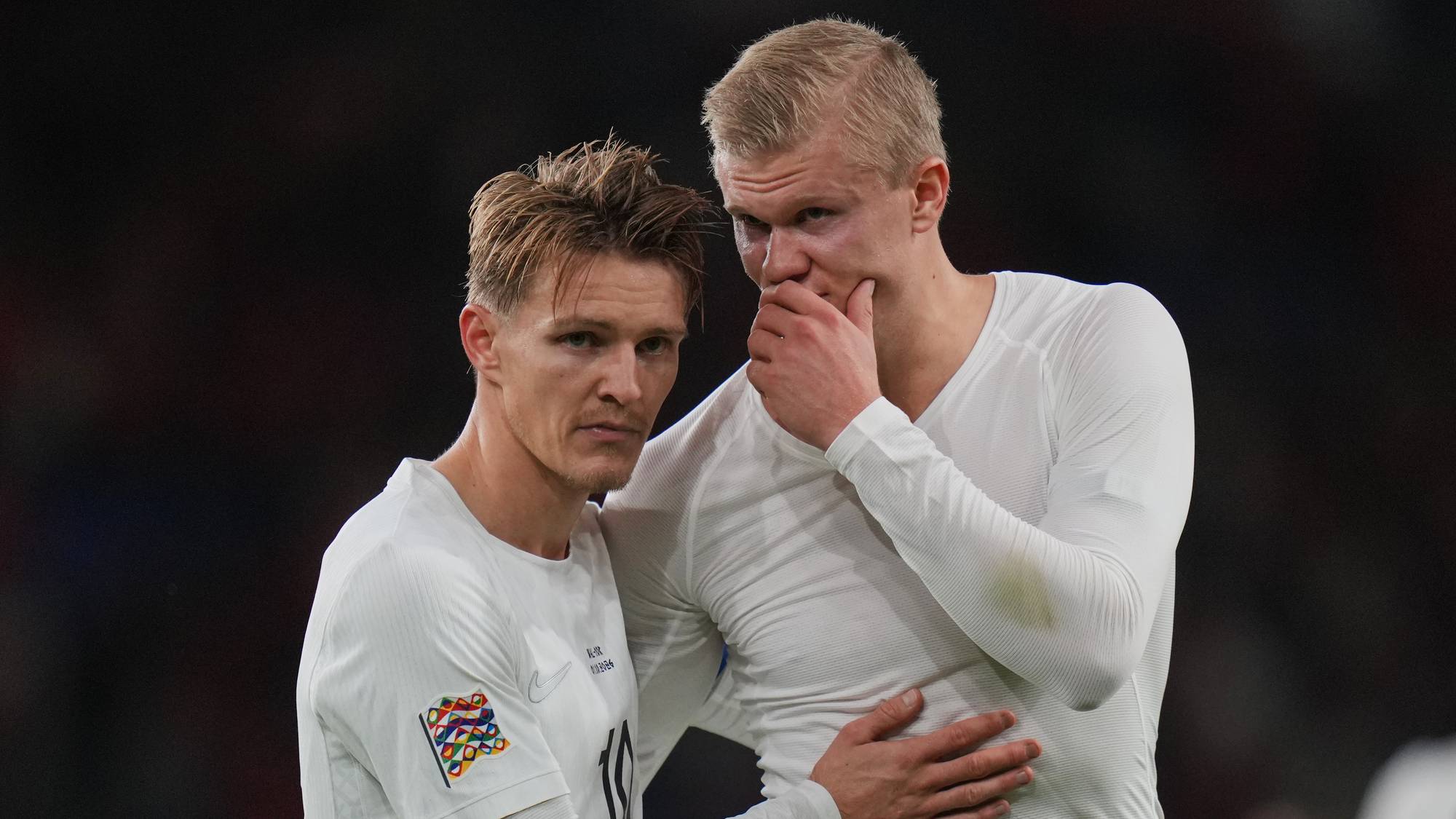 Martin Ødegaard og Erling Braut Haaland i norske landslagsdrakter på fotballbanen. (Bildebeskrivelsen er laget av en KI-tjeneste)