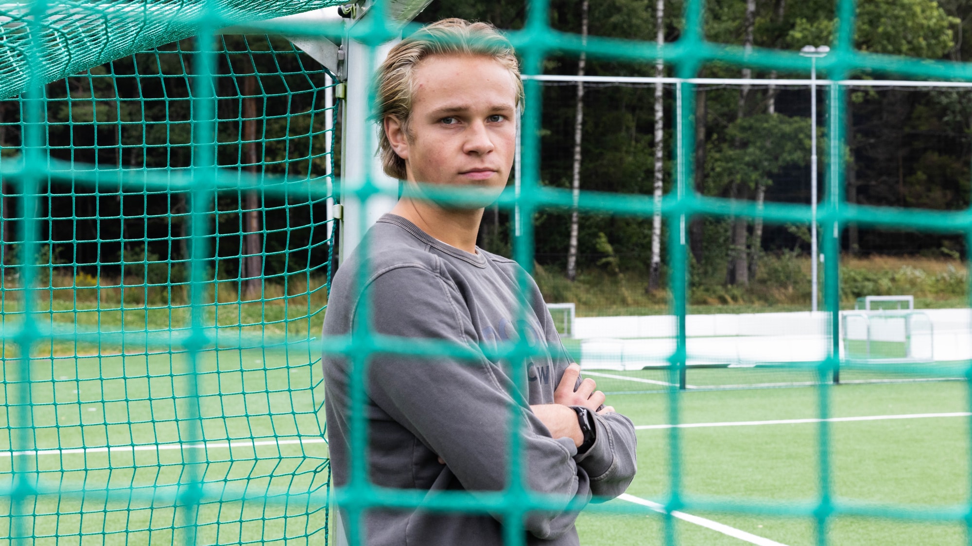 Bilde av Jesper Sandberg som står inne i et fotballmål. Foran han kan man skimte konturen av et fotballnett som ikke er i fokus. 