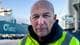 Nicolai Frøystad Delebekk / NRK En person i en neonfarget jakke står foran et stort skip med teksten "UECC" synlig. Bakgrunnen viser flere parkerte biler og industrielle strukturer. Det er klart vær med noen skyer. Scenen gir inntrykk av en aktiv havn. (Bildebeskrivelsen er laget av en KI-tjeneste)