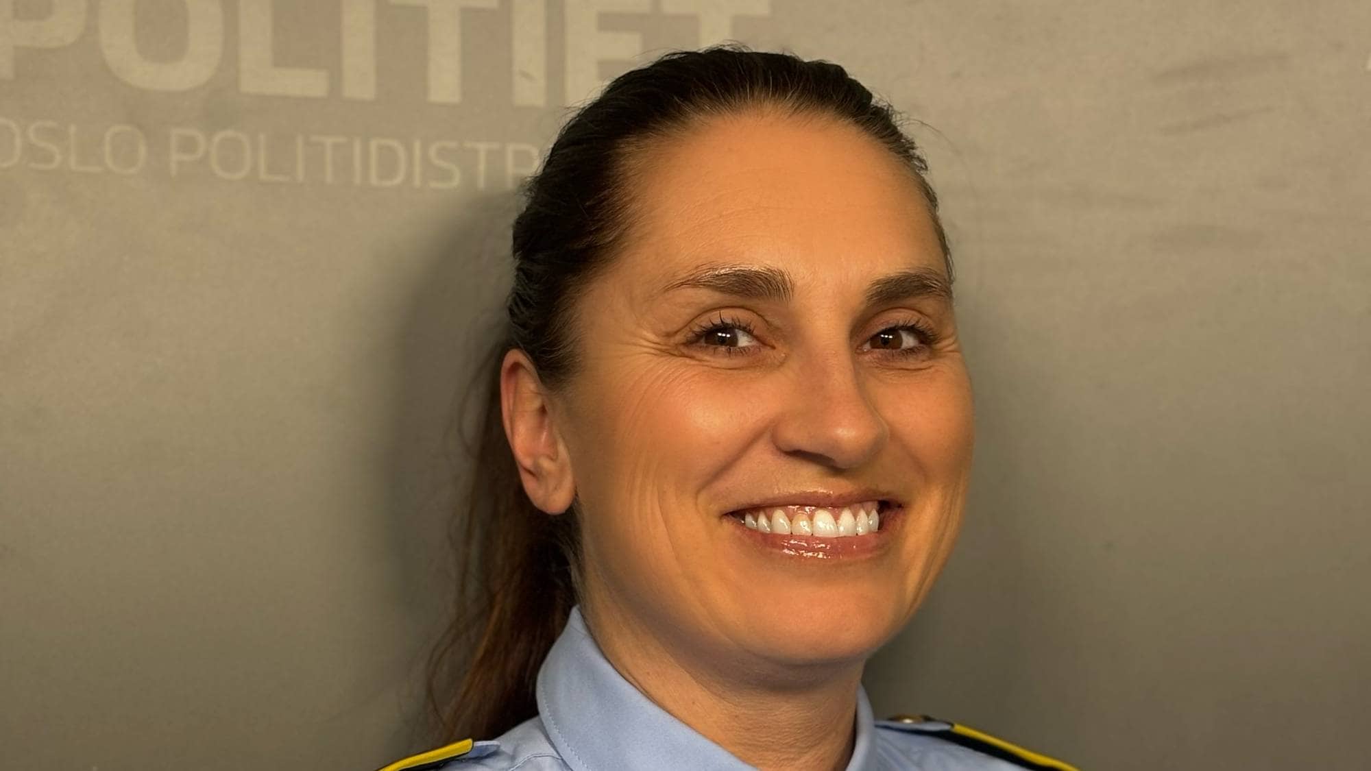 Janne Merete Breistein har på seg politidrakt og smiler til kameraet