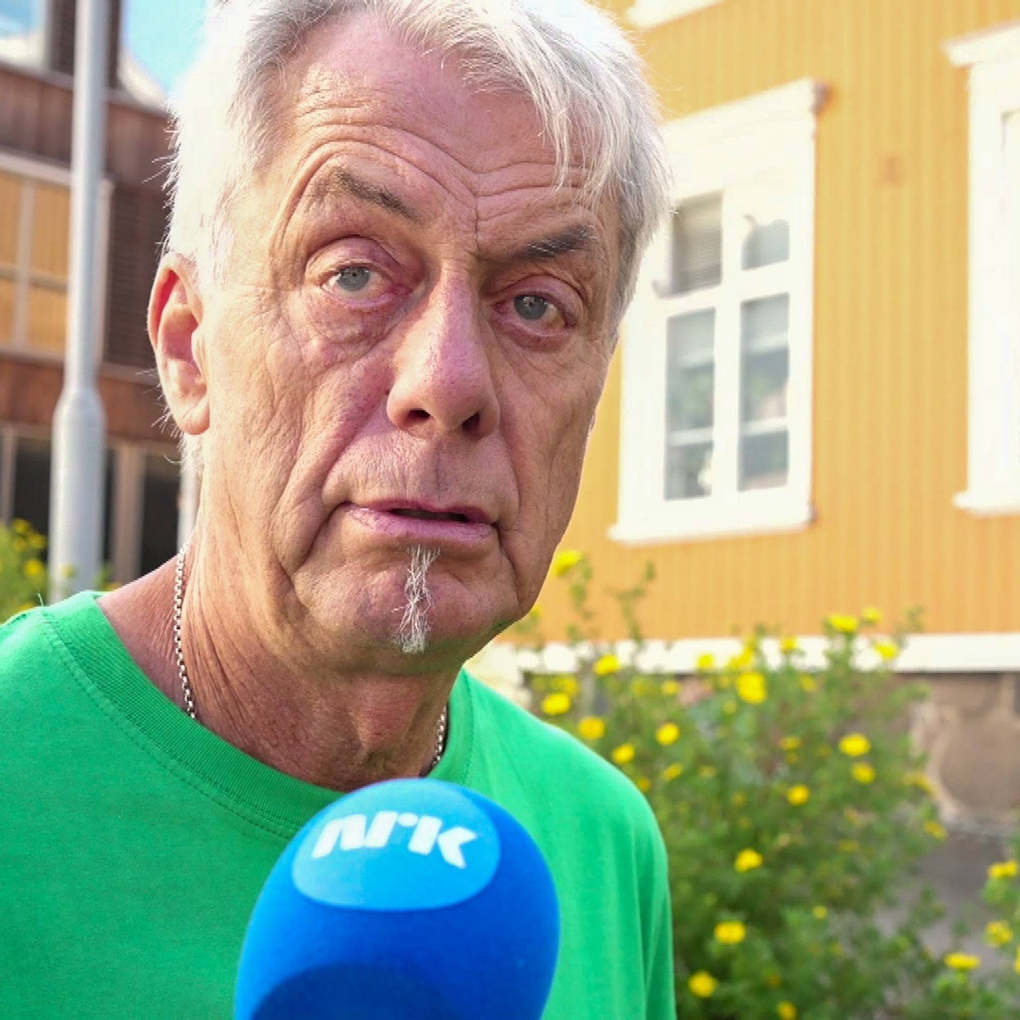 en eldre mann med hvitt kort hår og grønn t-skjorte.