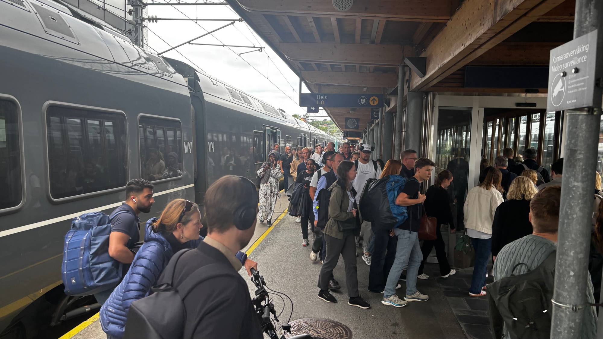 Reisende går av et tog på en perrong. 