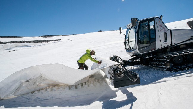 Her legger Per Arne og kollegaen en plast()duk over isbreen for å bevare breen.