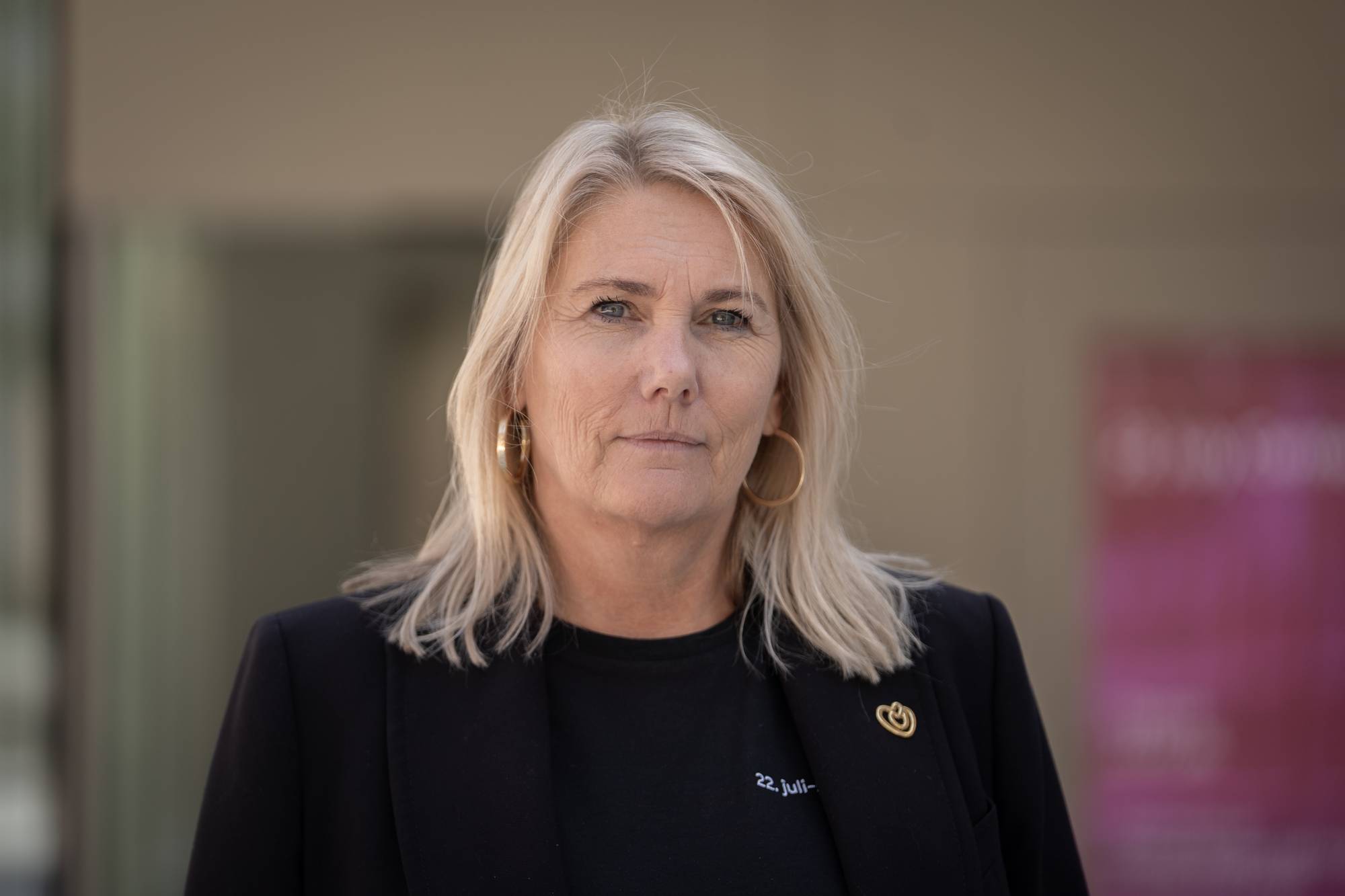 En kvinne fotografert foran en nøytral bakgrunn. (Bildebeskrivelsen er laget av en KI-tjeneste)