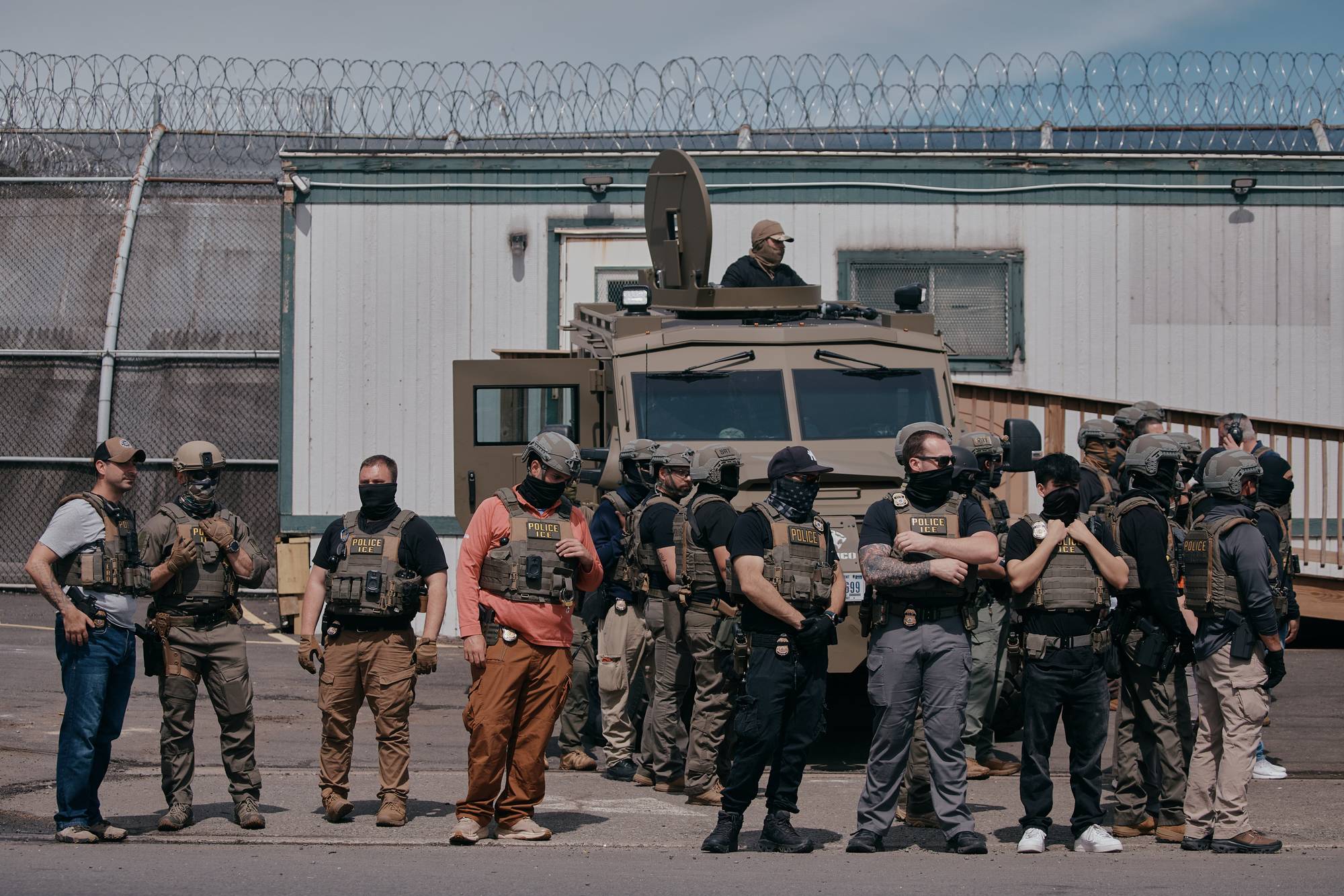 En gruppe personer i uniform med vest står foran en pansret bil. De ser ut til å være en del av et politi- eller sikkerhetsteam. (Bildebeskrivelsen er laget av en KI-tjeneste)