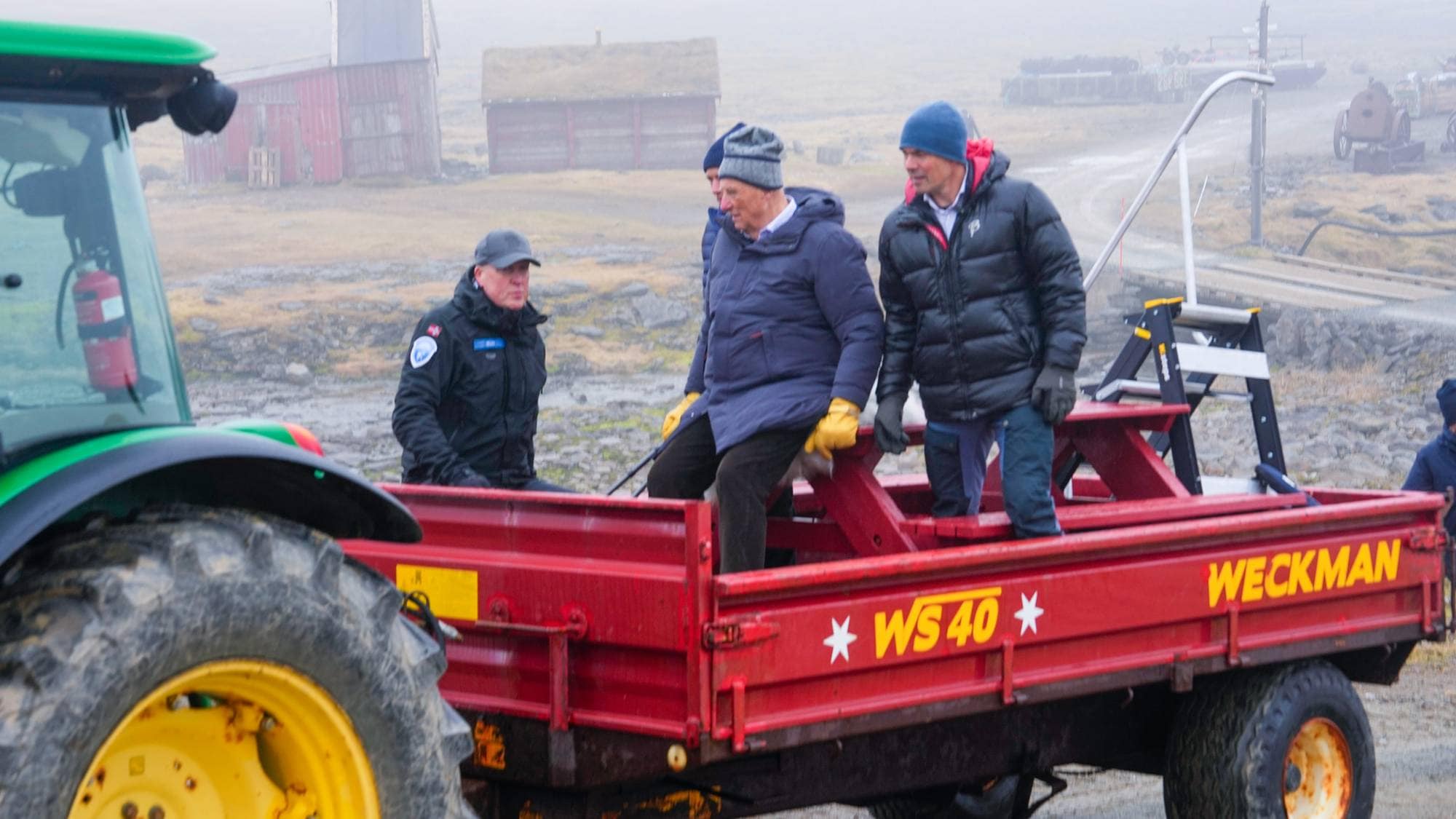 Kong Harald blir kjørt med traktor på Bjørnøya