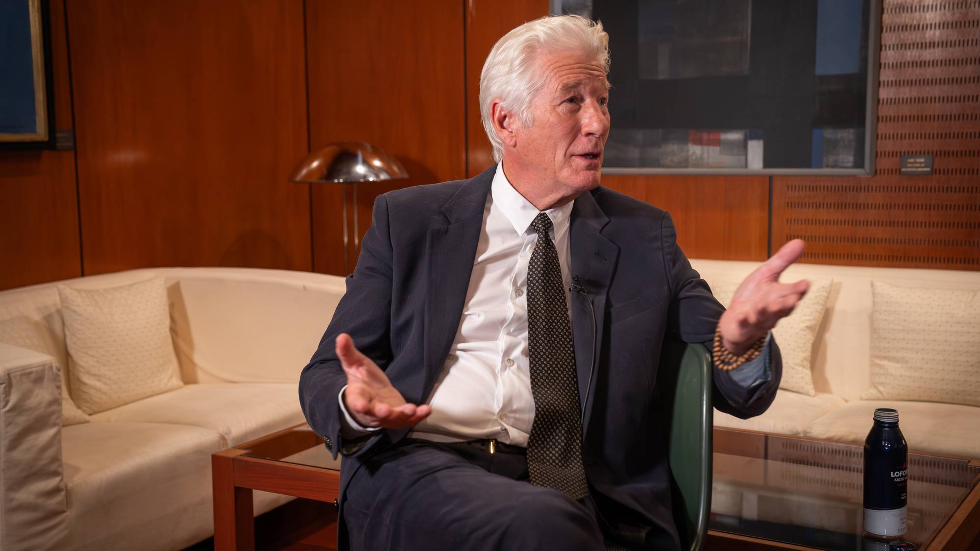 Richard Gere sitter i en stol og blir intervjuet. 
