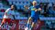 Foto: Thomas Andersen / NTB Fotballspiller i blå drakt fører ballen på banen med en motspiller i hvitt og rødt bak seg. (Bildebeskrivelsen er laget av en KI-tjeneste)