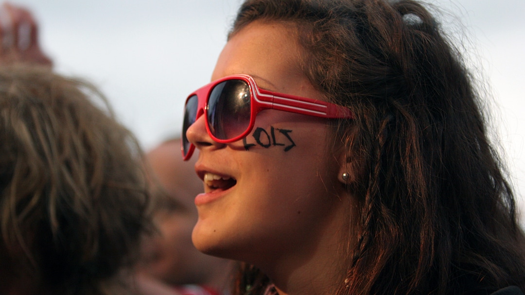 Jente med røde solbriller. I profil.