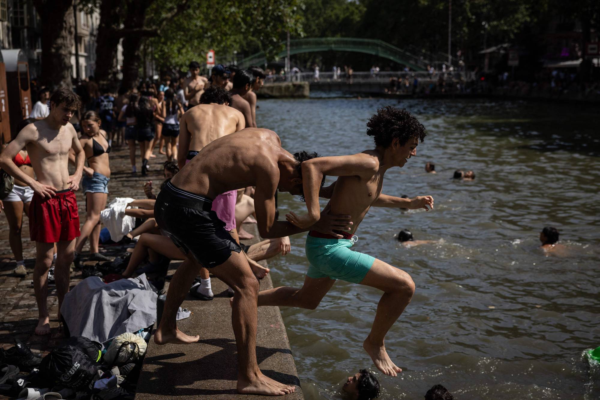 Ungdom hopper i en kanal i Paris for å kjøle seg ned på en varm dag.