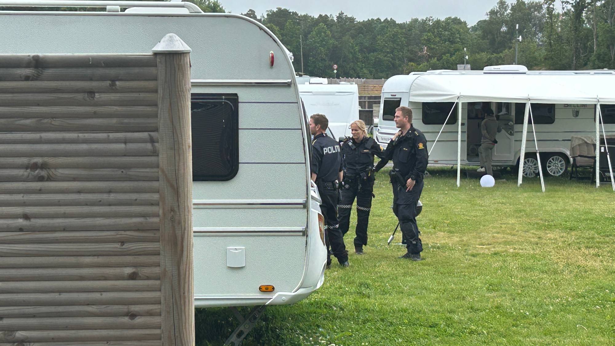 Bildet viser politifolk på en campingplass.