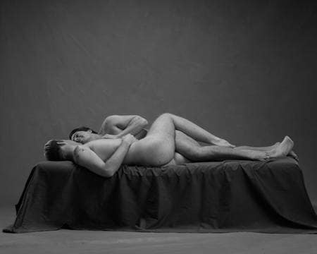 To nakne menn holder rundt hverandre i senga