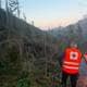 Rjukan og Tinn Røde kors Hjelpejorps Mann i rød refleksvest fra Røde Kors går i et terreng med veltede trær.