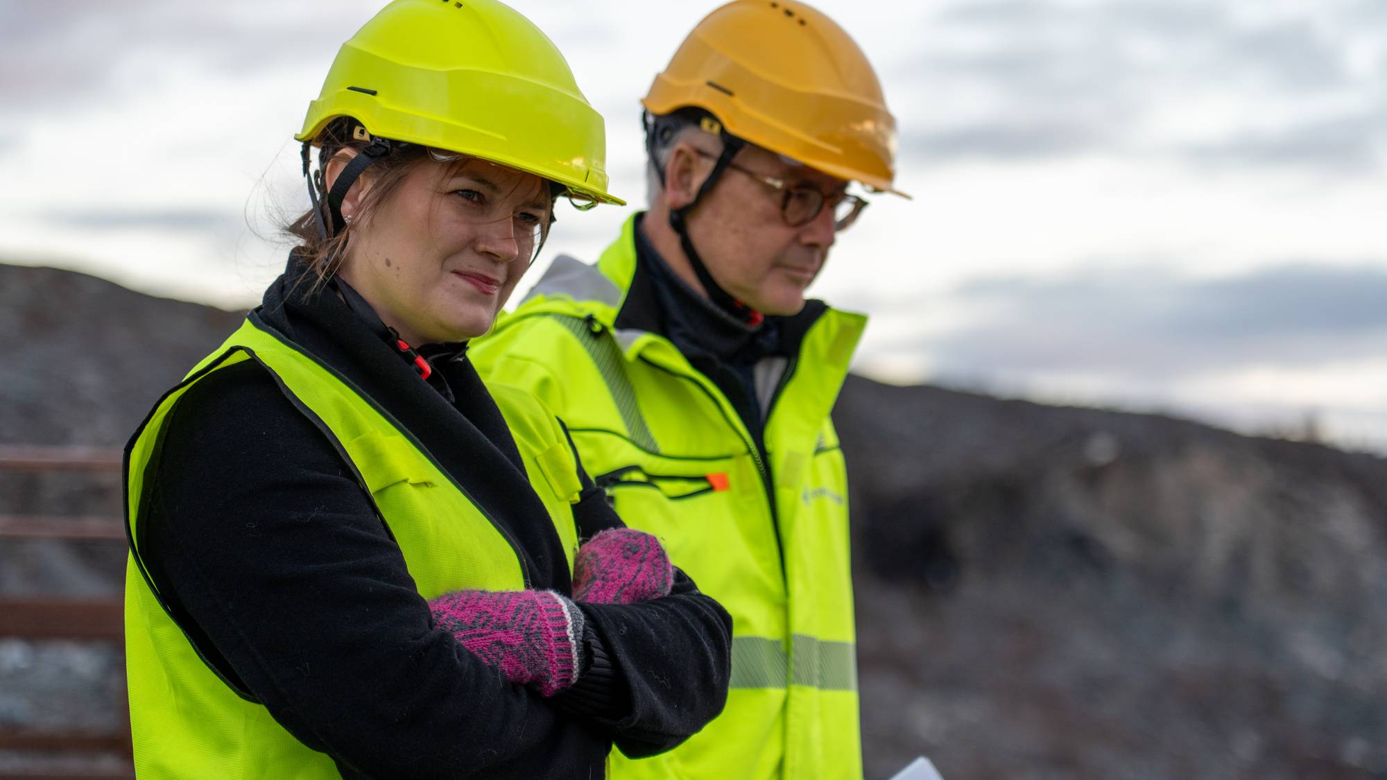 En mann og en kvinne med gule vernehjelmer og refleksvester