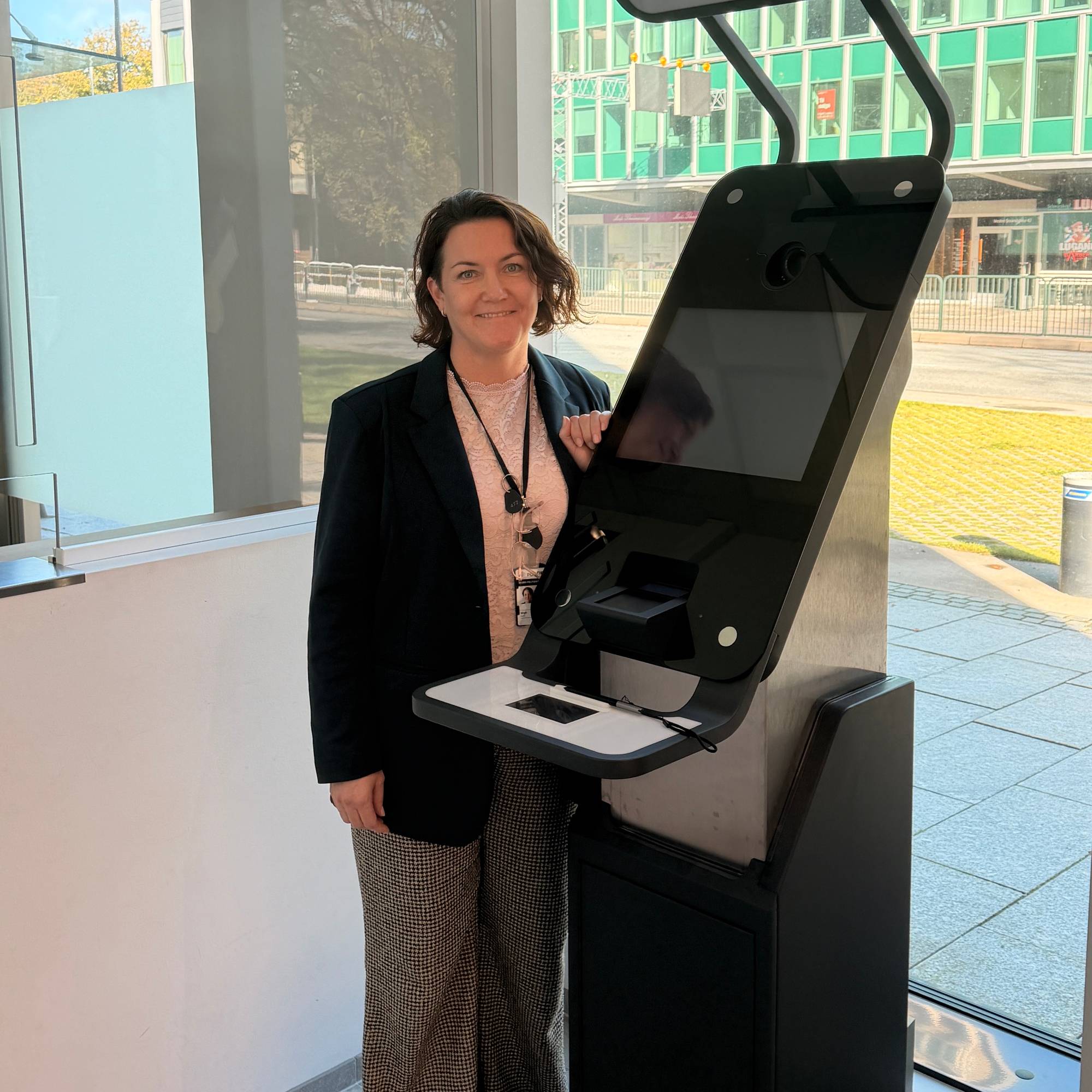 Carine Wigh, avdelingsleder Pass og Id Agder politidistrikt står ved en køautomat.