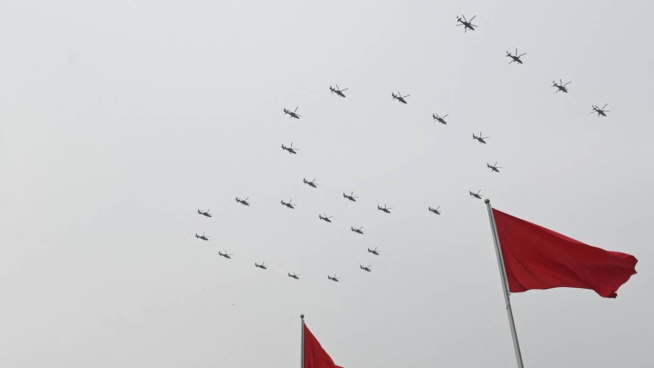 Gli elicotteri volano in formazione durante la celebrazione del centesimo anniversario della fondazione del Partito Comunista Cinese. 