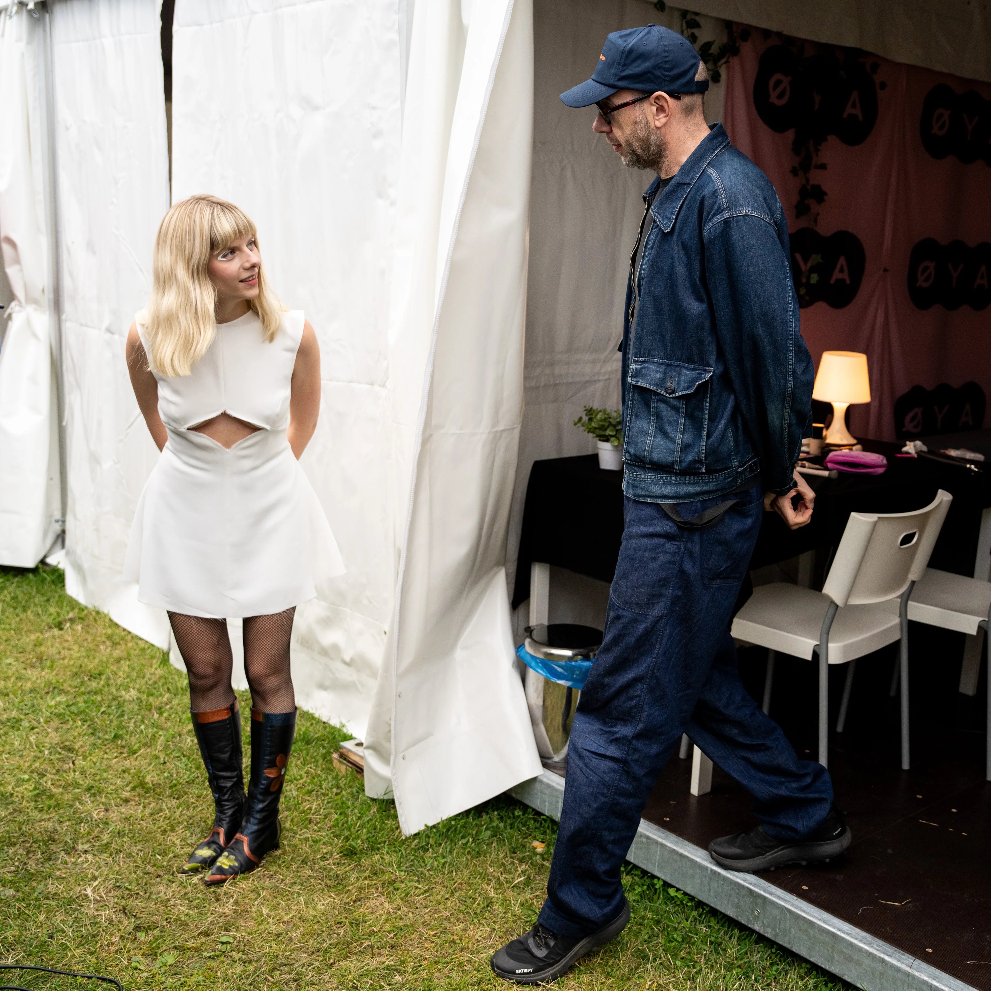 Aurora ser på Tom Rowland som kommer ut fra backstageteltet.
