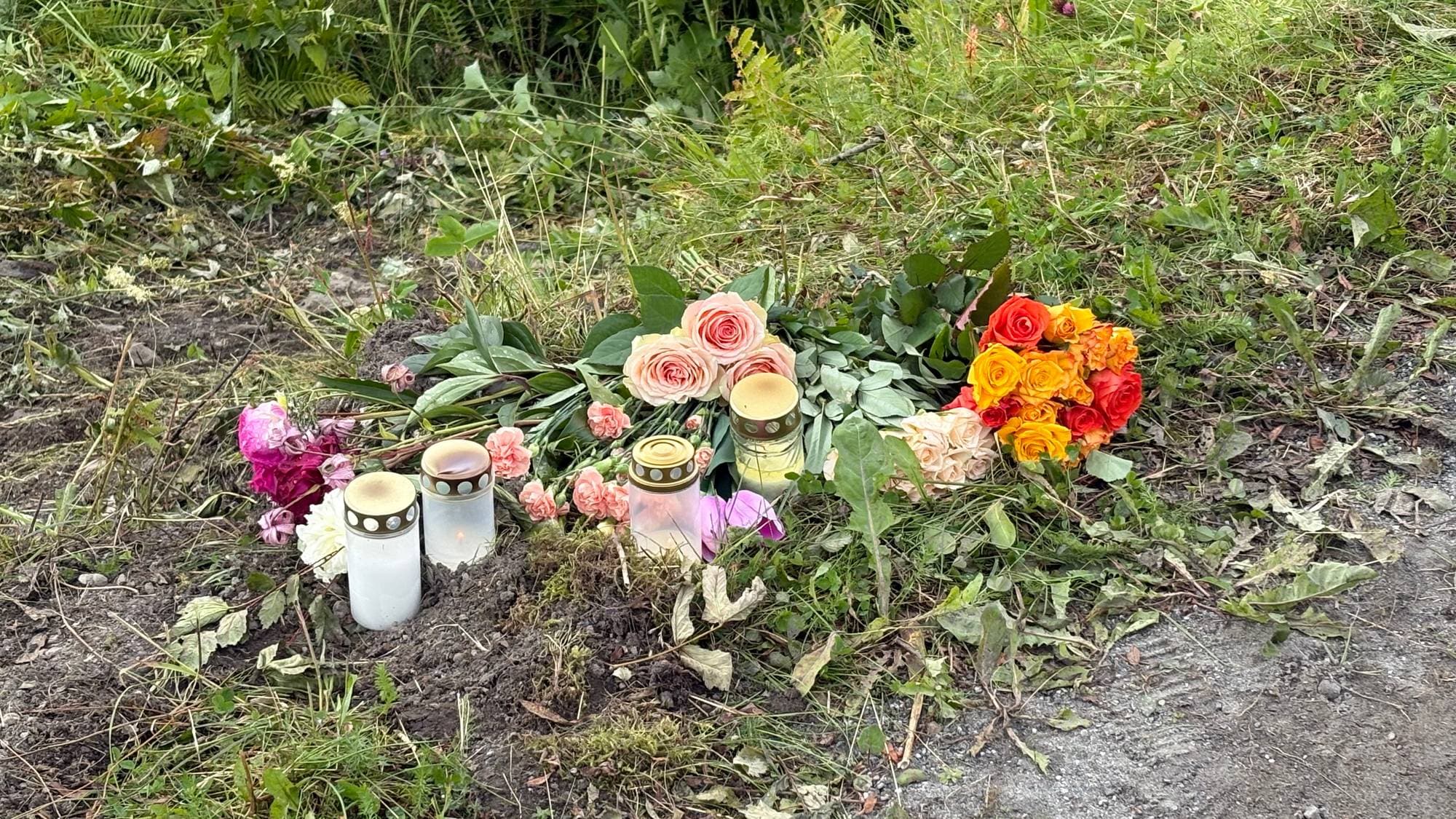 Blomster og gravlykter i veikanten. 