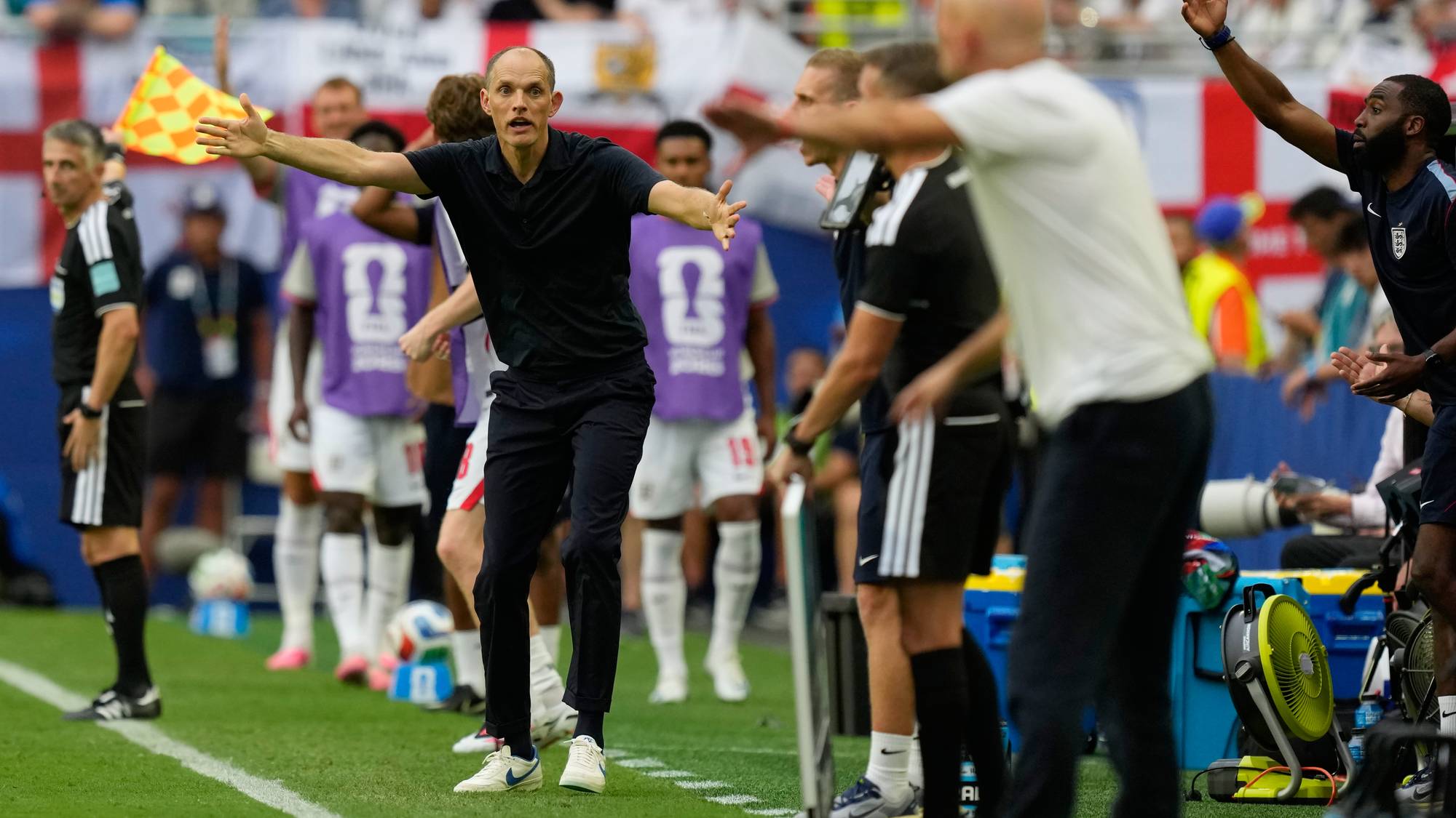 Thomas Tuchel gestikulerer ivrig på sidelinjen under en fotballkamp med spillere i bakgrunnen. (Bildebeskrivelsen er laget av en KI-tjeneste)