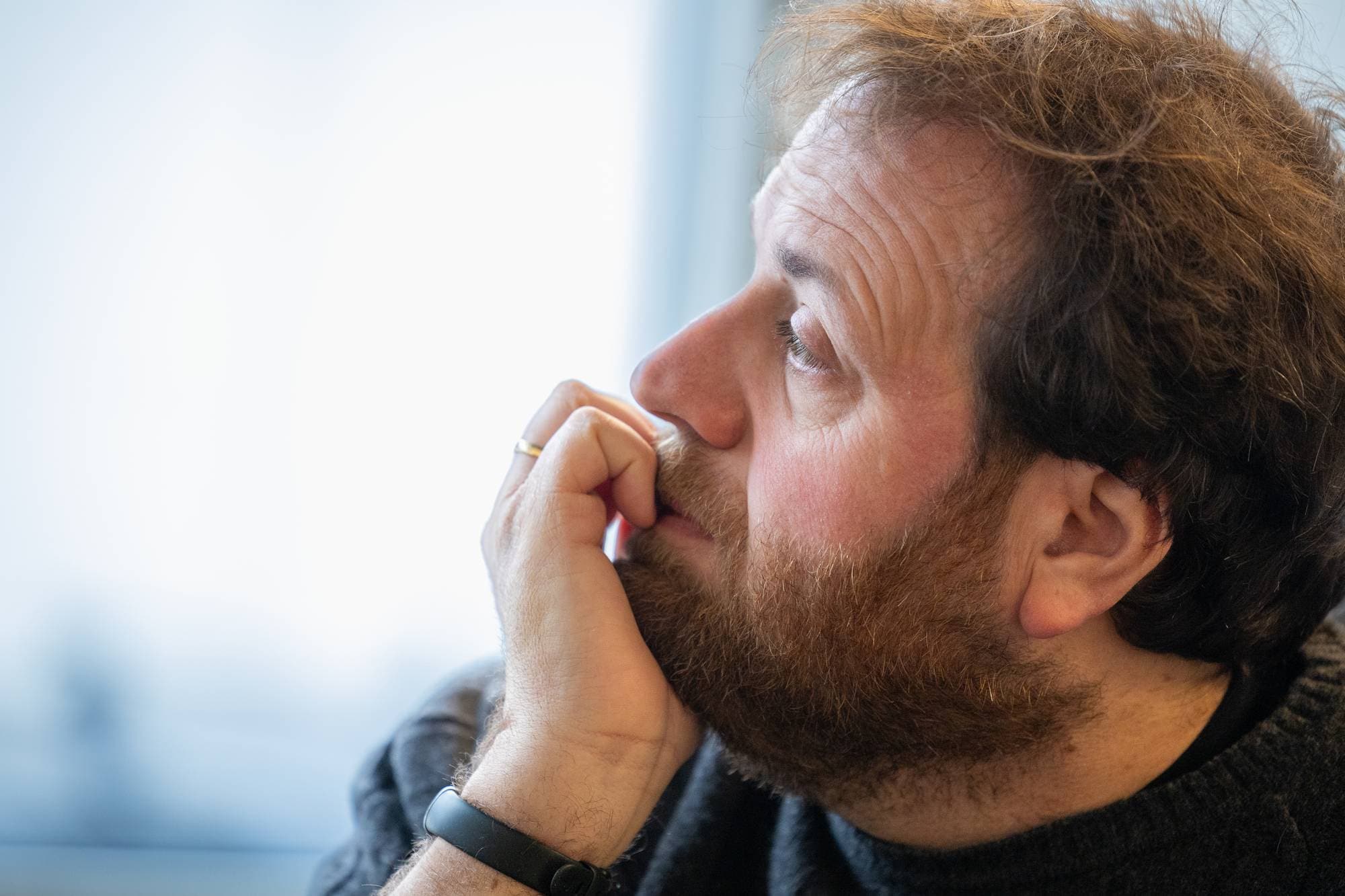 Ronny lener seg på hånda si mens han ser tankefullt ut av vinduet.