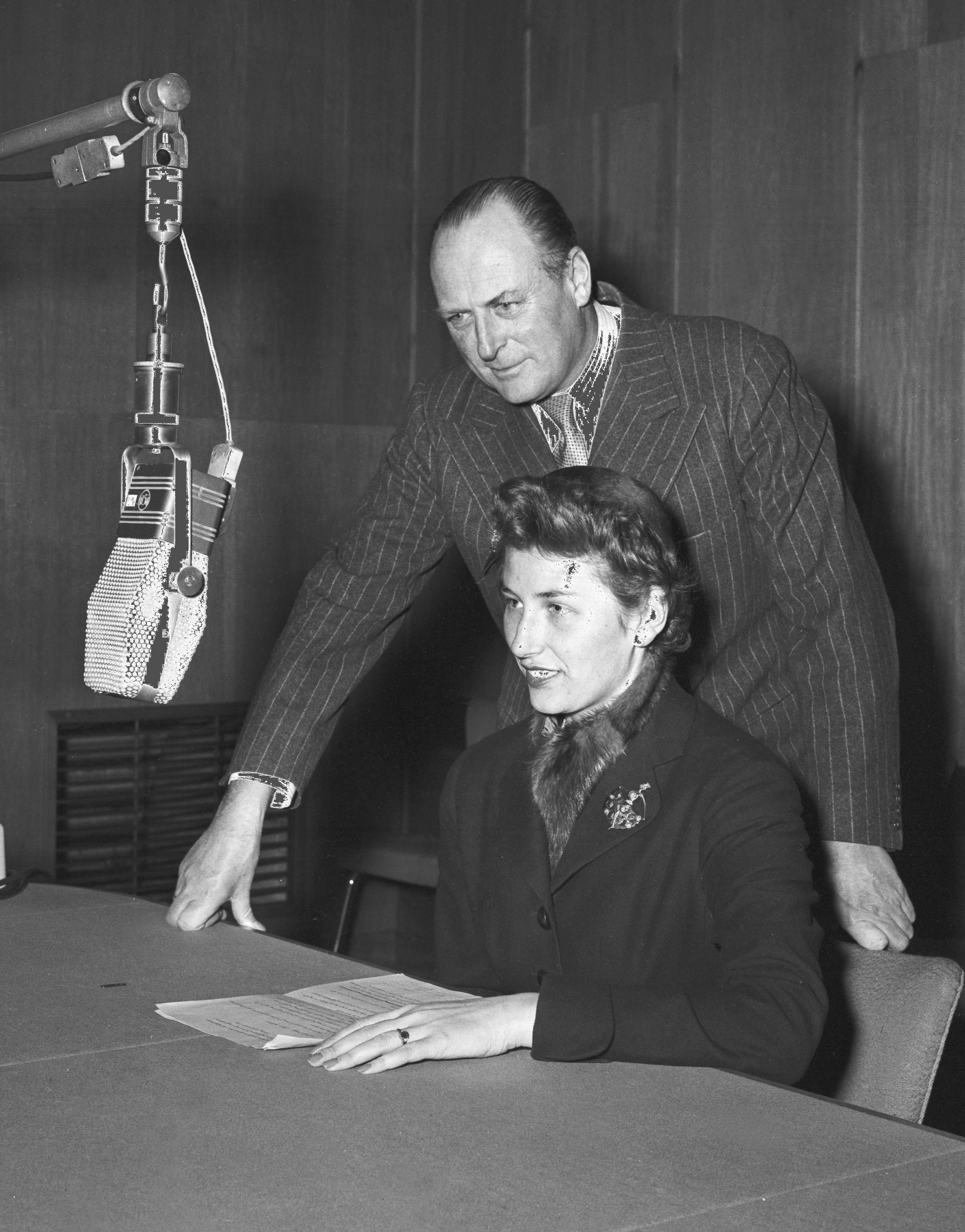 Oslo 19551121. 50 års-jubileum for den norske kongefamiliens ankomst til Norge. Kong Haakon måtte tilbringe sin store dag i sengen på Rikshospitalet etter benbruddet i juni.Kringkastingen feiret kong Haakon hvor prinsesse Astrid holdt sin første tale i radio som var en gripende og velformet hyllest til kongen og bestefaren. Her sammen med sin far kronprins Olav. Mikrofoner.Foto: Jan Stage NTB / Scanpix HISTORISKEBILDER