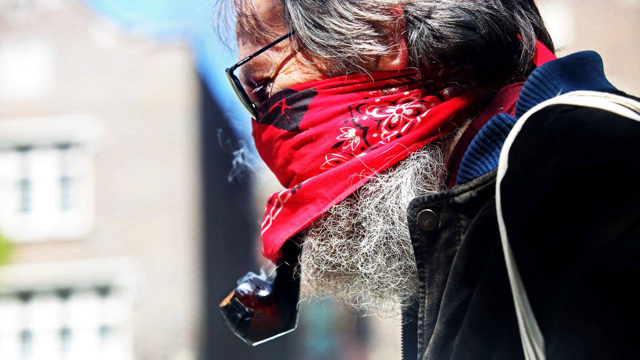 I Brooklyn i New York røyker Tom Bonnett pipe under munnbindet mens han lørdag går en tur i Prospect Park.