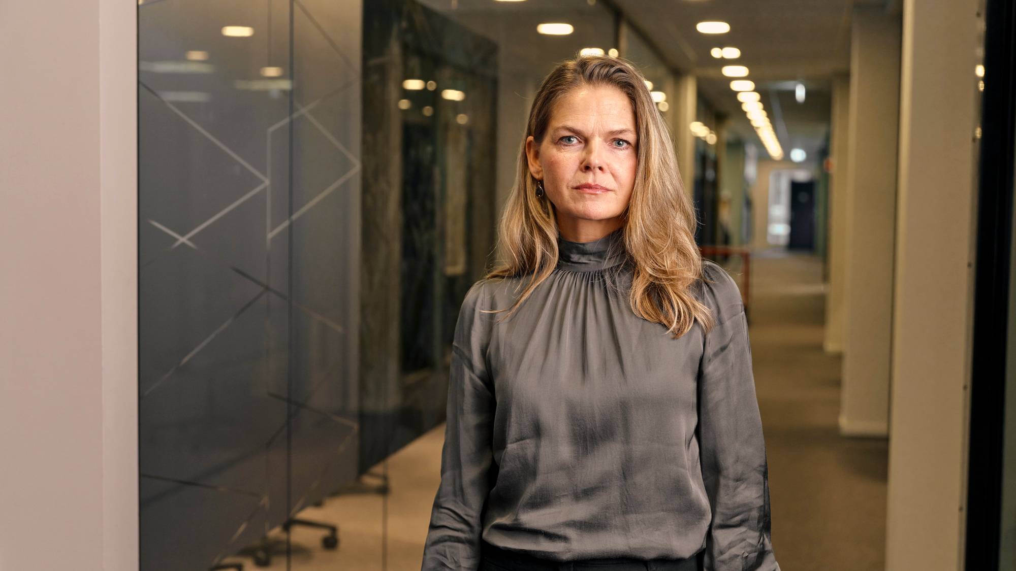 Bilde av divisjonsdirektør Tove Bruusgaard i Bufdir, fotografert i en kontorgang. 