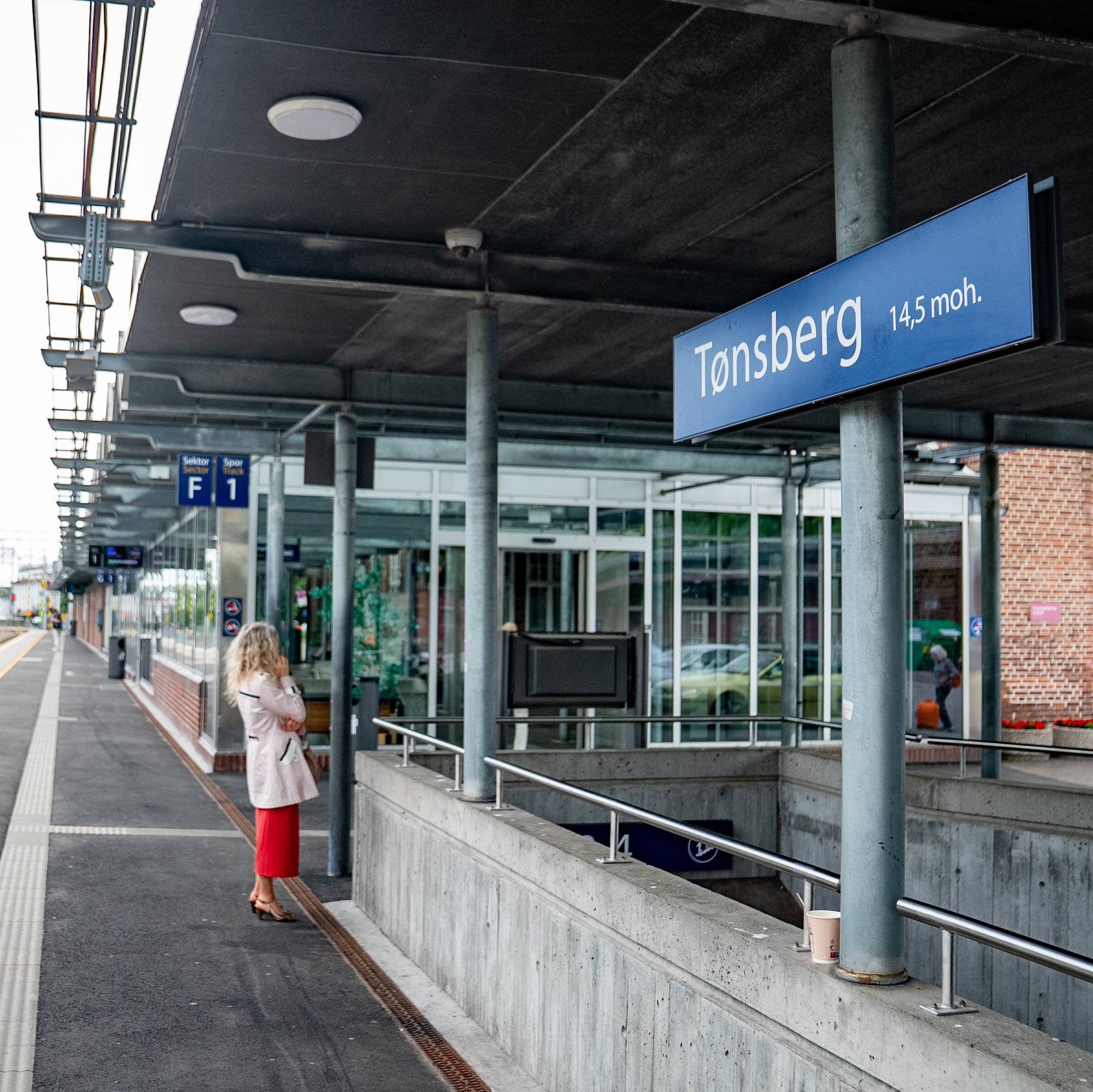 En jente som står på en plattform ved siden av en togstasjon (Bildebeskrivelsen er laget av en KI-tjeneste)