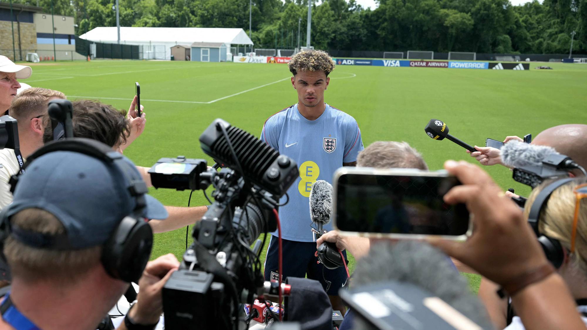 Engelsk fotballspiller intervjues av en gruppe pressefolk på en treningsbane. (Bildebeskrivelsen er laget av en KI-tjeneste)