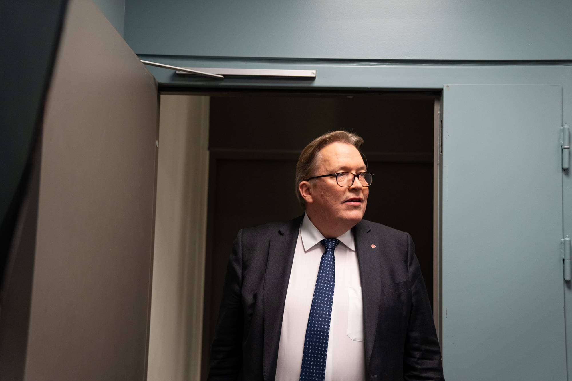 Mann i dress går inn i rom