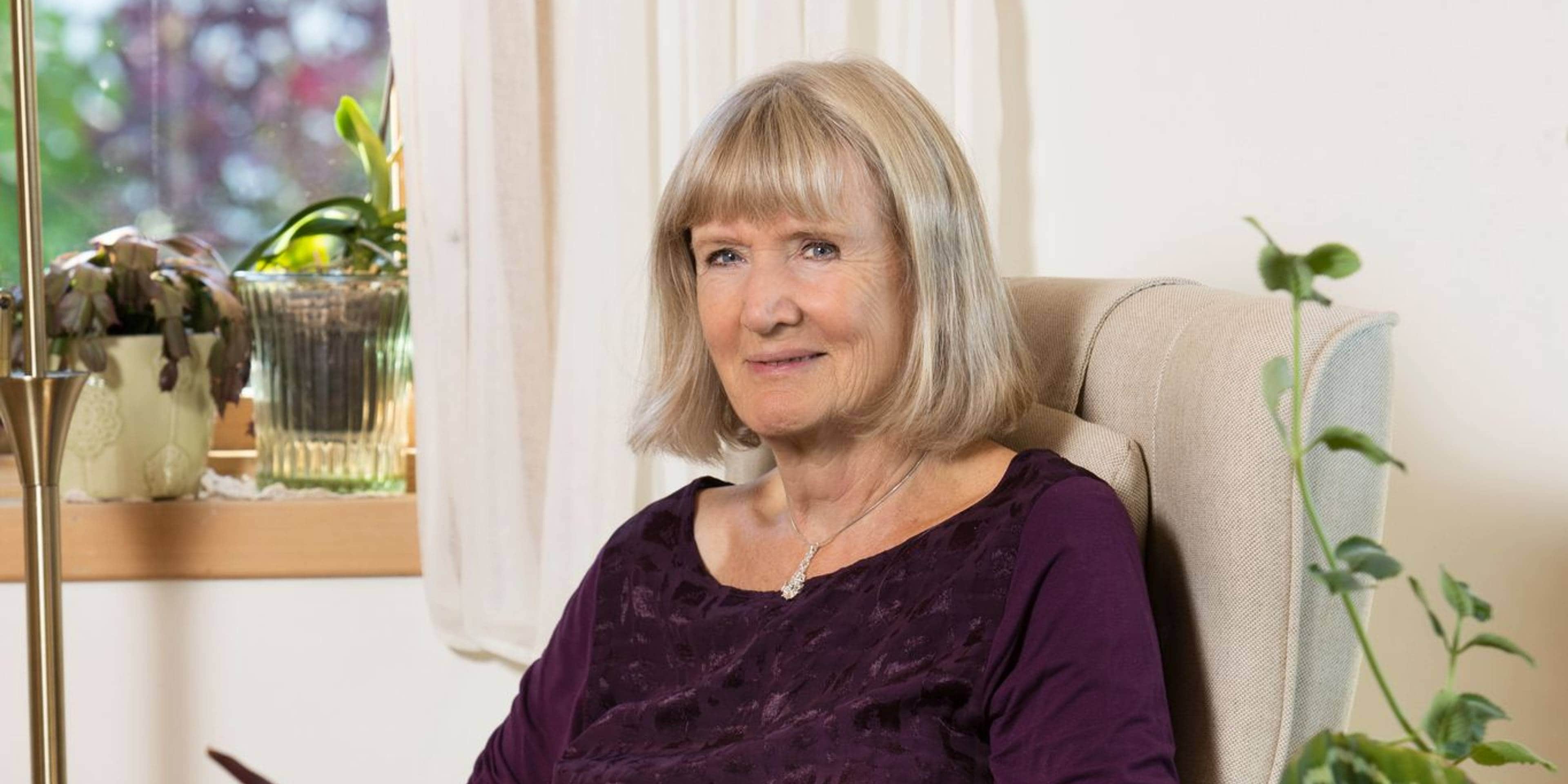 Psykolog og tidligere advokat Grethe Nordhelle sitter i en stol og ser rett i kamera. Hun har kortklipt hår og smiler.