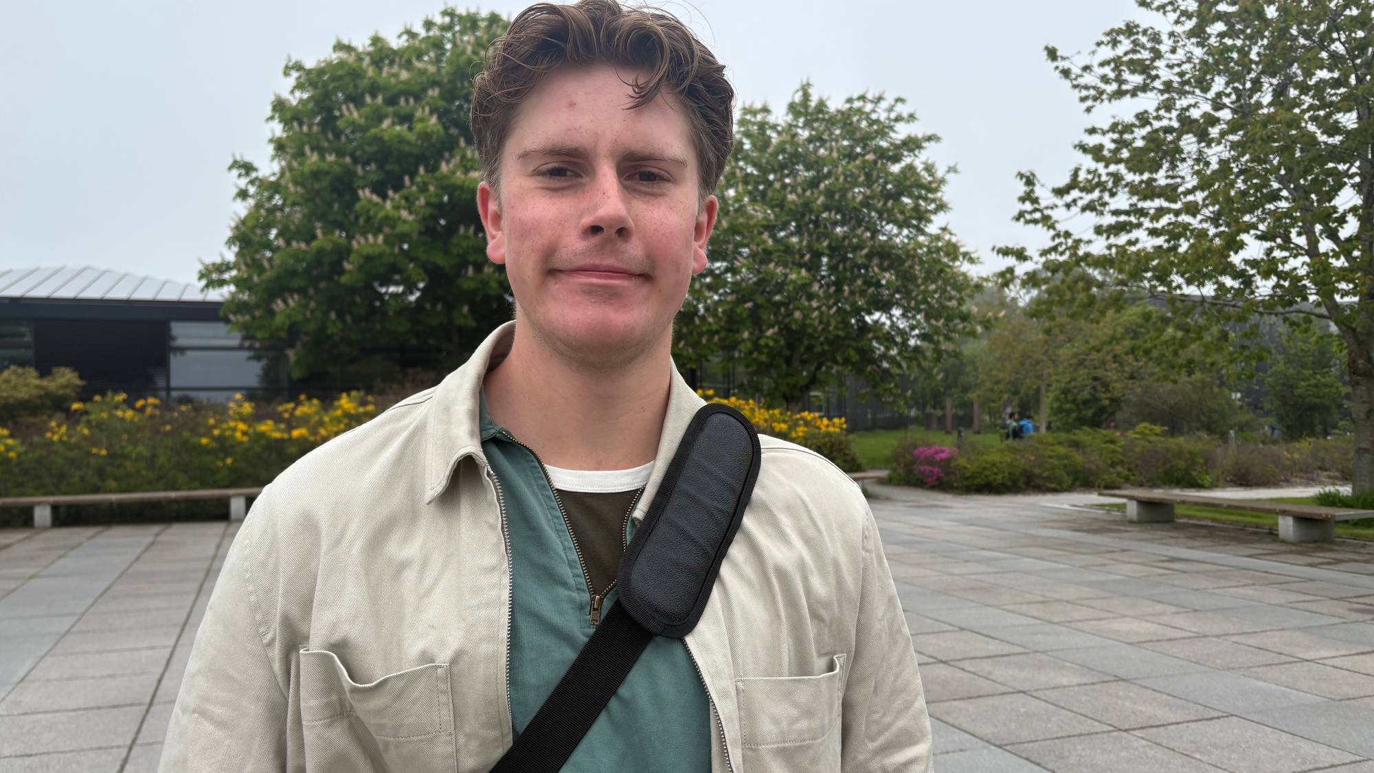Student som står på en åpen plass.