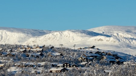 Et stort hytte-område foran et fjell med snø